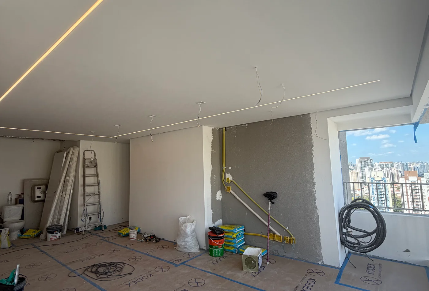 Reforma de apartamento em andamento, com proteção do piso e preparação dos acabamentos